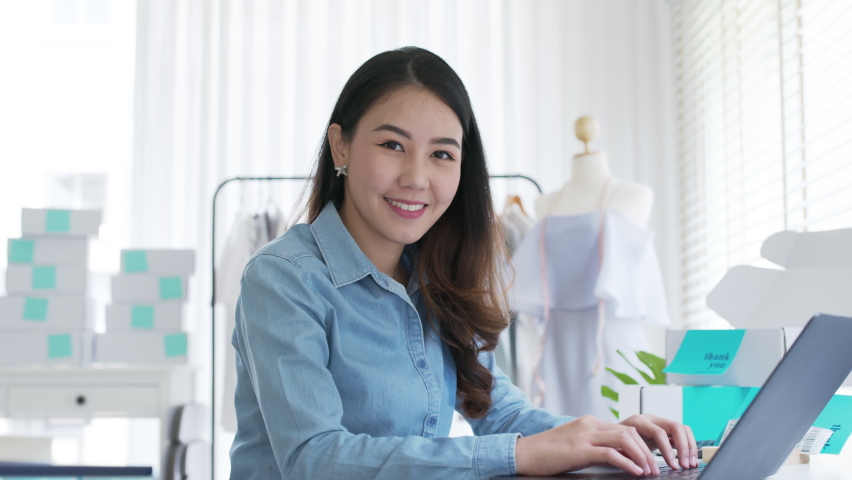 Portrait young attractive asia female owner startup business look at camera work happy with box at home prepare parcel delivery in sme supply chain, procurement, omnichannel commerce online concept. | Shutterstock HD Video #1068928031