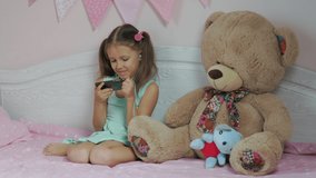 Little Girl At Home Bedroom On Bed Communicating