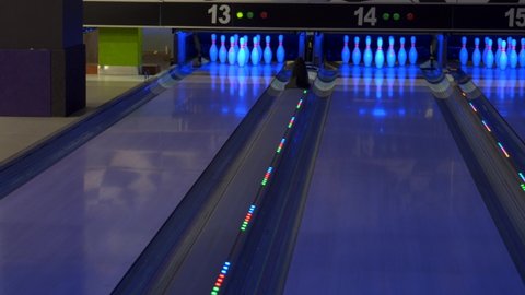 MARIUPOL, UKRAINE - January 24, 2021 : Colorful bowling alley. Bowling game. A bowling ball traveling down the lane and knocks down pins