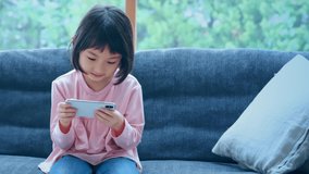 Little girl watching movies with a smart phone. Communication network.
