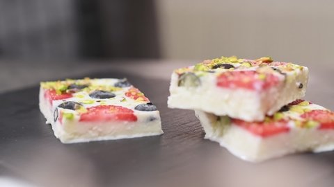Pieces of frozen yogurt bark with strawberries, blueberries and pistachios.