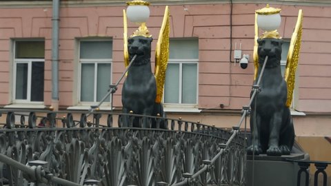 bank bridge in St. Petersburg is guarded by Griffins with golden wings, a favorite attraction of townspeople and tourists blurry motion, zoom out, time lapse