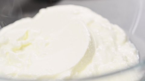 Adding sweetened condensed milk to the yogurt. Process of making frozen yogurt bark.