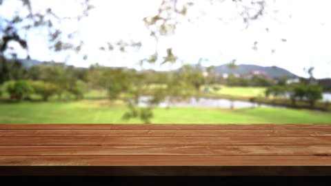 4K.UHD 4096x2304. 25.FPS. Close up Top Wood table bar and nature tree bokeh blurred background. At morning time and beautiful nature sun light, Top wood table space area for products shows.
