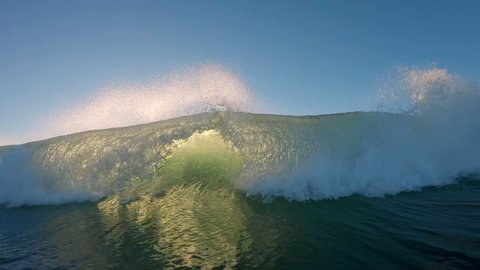 Ocean wave breaks at sunrise. Powerful ocean wave breaks on the camera during sunrise