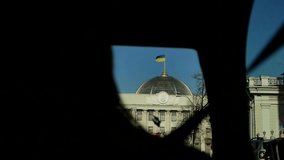 Video shooting from a car while traveling in Kiev and Ukraine. The fluttering Ukrainian flag over the parliament building in the center of Kiev. Verkhovna Rada of Ukraine. The house of government.
