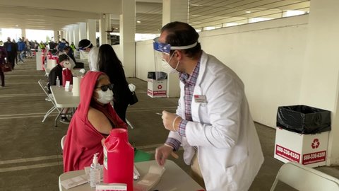 People receive the new one-shot Johnson and Johnson COVID-19 vaccine at a vaccination site in Covina, California, on March 13, 2021.