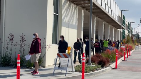 People wait in line for the new one-shot Johnson and Johnson COVID-19 vaccine at a vaccination site in Covina, California, on March 13, 2021. 