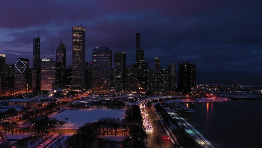 Urban Skyline of Chicago Loop at Night in Winter. New Eastside and Lake Michigan. Blue Hour. Aerial View. United States of America. Drone Flies Sideways and Upwards Royalty-Free Stock Footage #1068968971