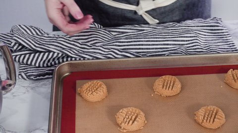 Step by step. Scooping peanut butter cookies dough with dough scooper into the baking sheet.