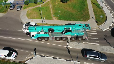 Belarus, Minsk - August 28, 2020: Truck crane driving on an asphalt road in the city. Aerial view