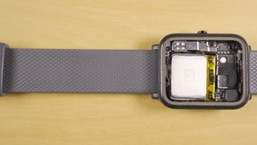 Disassembled smartwatch showing the interior, battery, different sensors and CPU. - Powered by Shutterstock - Get 15% off with code: PIKWIZARD15