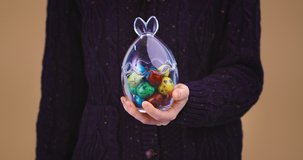 Easter celebrating female opens glass vase full festive painted colourful quail eggs, close up video