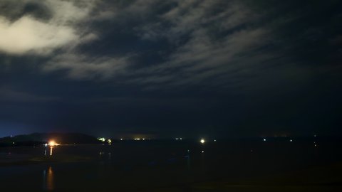4k time lapse of cloudy night at Kuantan beach, Malaysia with star trail. Zoom out