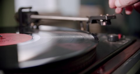 Hand turns on a vintage vinyl record and vinyl record is spinning. Vercion 4