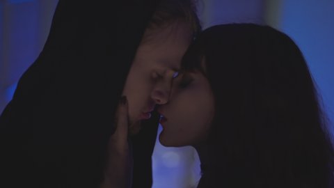 Attractive young man and woman passionately kissing each other in the dark alley.