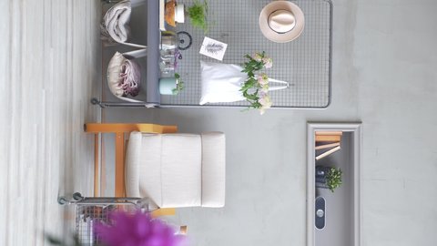 Grey stone wall and rocking chair, close up purple flower, white brick wall, plant in the white bag living room style. Vertical screen.