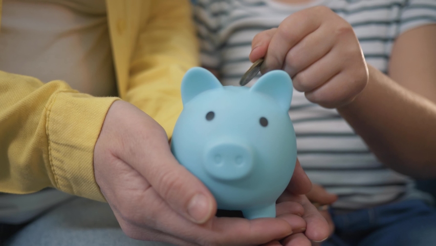 Family piggy bank for investment. Happy family throws coins into piggy bank. The girl hand throws coins into piggy bank. Family business. Mom and daughter are counting coins. Girl with piggy bank Royalty-Free Stock Footage #1069016179