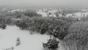 Snow-covered winter park near the city. Flying a drone in the snow