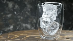 pieces of ice fall into a double-walled glass. Close-up, slow motion. Iced drink - Powered by Shutterstock - Get 15% off with code: PIKWIZARD15