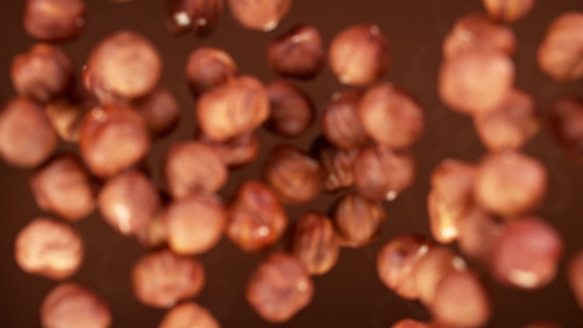 Super Slow Motion Shot of Hazelnuts Falling into Melted Chocolate at 1000 fps. Royalty-Free Stock Footage #1069031437