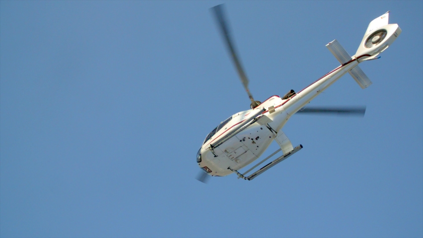 Helicopter take off in slow motion. Taken from under side showing bell of heli and rotor spinning. Royalty-Free Stock Footage #1069036942