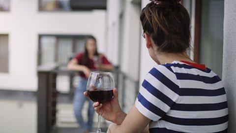 Handheld video of neighbors drinking wine on the balcony. Shot with RED helium camera in 8K