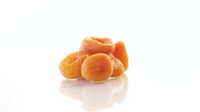 delicious dried apricots in a bowl on white background