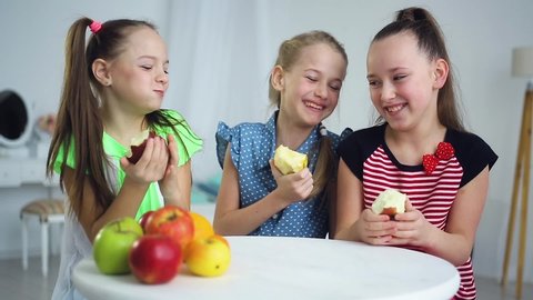Small group of children eating apples together