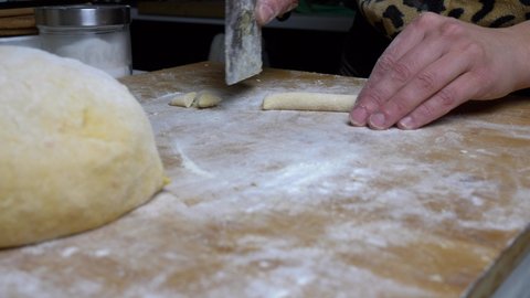 Close up woman cuts pieces of dough. Homemade Potato Gnocchi. Homemade pasta preparation. Slow motion 4K