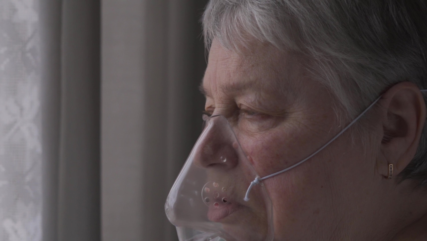 Senior Woman breathing with an oxygen mask calling mobile phone | Shutterstock HD Video #1069053922