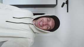 Vertical video of handsome young man making video call from home waving hand talking enjoying communication. Young smiling male blogger recording selfie video blog indoors. - Powered by Shutterstock - Get 15% off with code: PIKWIZARD15