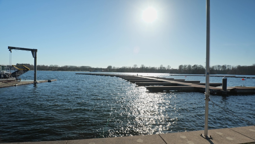 [4k] harbour pier at lake with sun reflection in the water