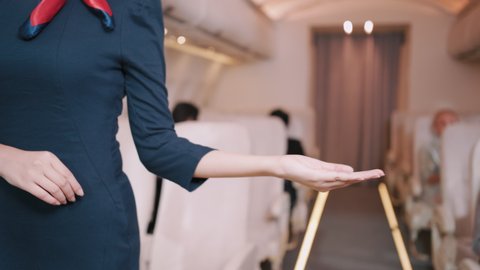 Airplane Stewardess Welcoming hand gesture on the plane flight, Business class. 4K UHD Footage.