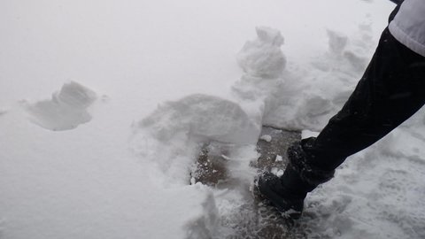 Close up of shoveling over a foot of densely packed snow during winter storm Xylia in Colorado