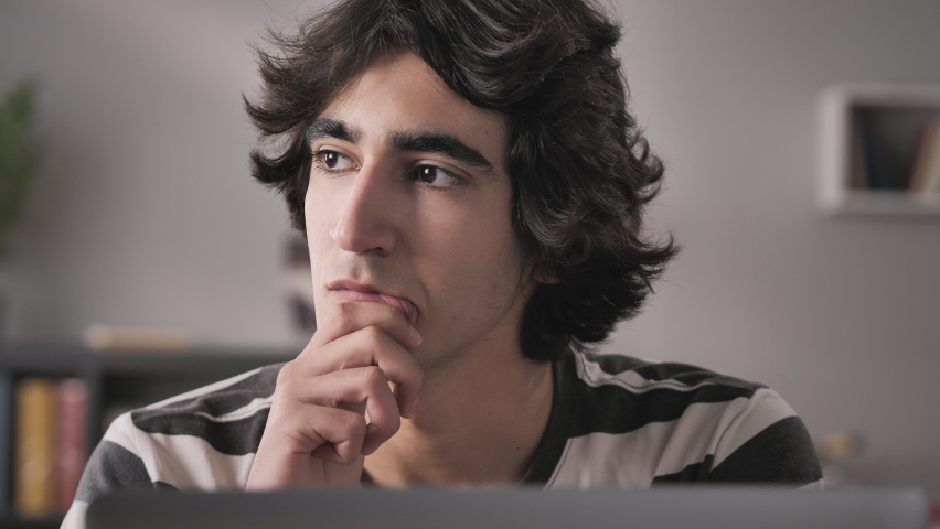 Portrait of thoughtful young man student thinking of problem solution working at computer,pensive serious male entrepreneur sits at the desk looking away at laptop ,millennial planning project Royalty-Free Stock Footage #1069070737