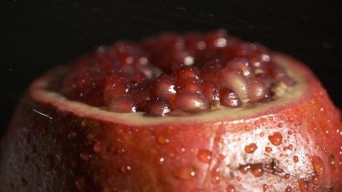 Pomegranate fruit. Slow motion shot. Fresh and ripe Pomegranates rotating over black Background. Organic Bio fruits close-up. Diet, dieting concept. Vegan foo