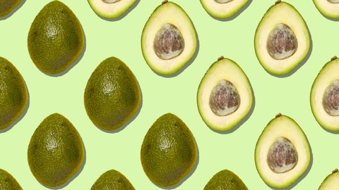 Stop motion animation Whole ripe avocados are replaced by half-pitched avocados diagonally on a green background