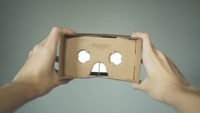 Wearing VR headset made of cardboard. First person point of view.