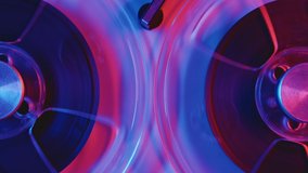 Reel To Reel Tape Recorder Playing RGB Led Light Neon Bulb. Rotating Vintage Music Player Close Up. Retro Tape. Spinning Reels Red Blue Color. View from Above. Disco Trends 60s, 70s, 80s, 90s. Retro - Powered by Shutterstock - Get 15% off with code: PIKWIZARD15