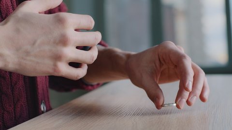 Close-up of male hands, cropped shot frustrated divorced deceived caucasian man husband takes off wedding ring puts on wooden table decides to separate, breakup marriage concept, end of relationship.
