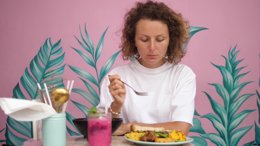 Young blonde woman eating her healthy delicious vegan breakfast. Enjoying solo travelling