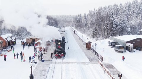 february 2021, Russia - Ruskeala: vintage retro steam locomotive stands on the platform with a passengers, thick steam moving up, aerial view
