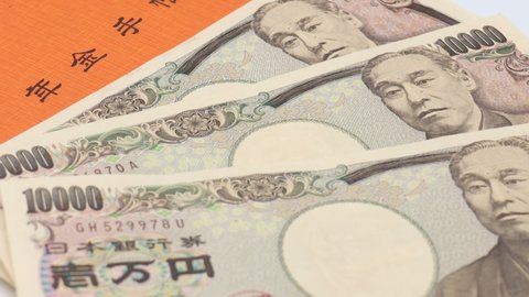 Orange pension book. 10,000 yen bill. Image of Japan's pension system. Translation: pension book.