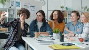 Slow motion of cheerful women diverse group taking selfie posing for smartphone camera at work. Photograph and modern technology concept. - Powered by Shutterstock - Get 15% off with code: PIKWIZARD15