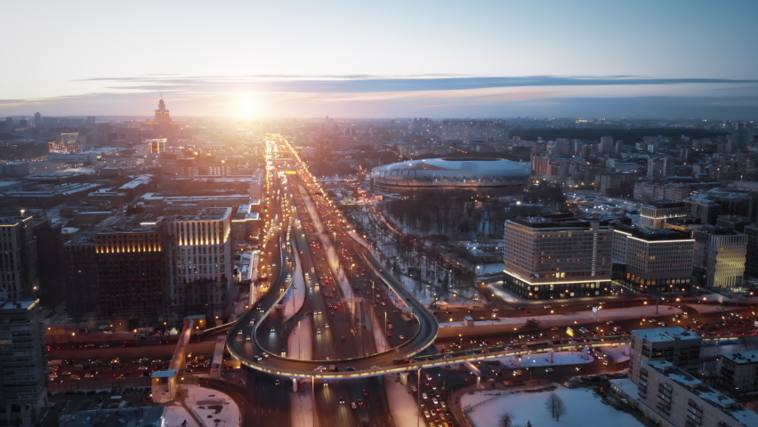 Aerial sunset panorama of Moscow highway with a lot of traffic in winter. Camera showing beautiful city and wide road with junctions and cars driving in the evening lights. Royalty-Free Stock Footage #1069111957