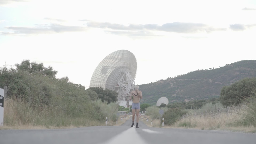 Man with gas mask running down a road without a shirt