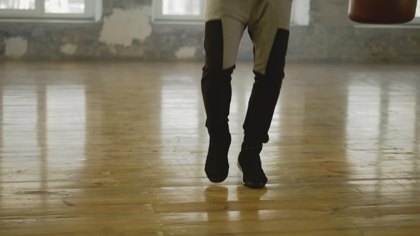 Boxer skipping the rope in an empty hall, listen music in headphones in slow motion