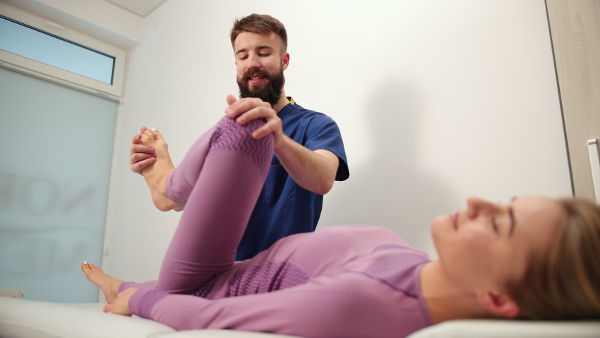 Knee pain patient, treatment, medical doctor, massage therapist. Syndrome. leg manual therapy kneading muscles joints. Woman's thumb joint being manipulated by osteopathic. Bearded man in hospital Royalty-Free Stock Footage #1069119979