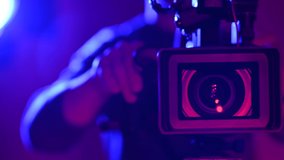 Professional Camera Operator. Documentary Film Stage in Pinky Blue Illumination.